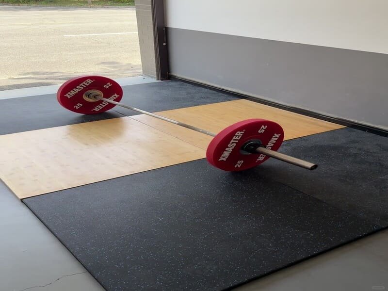 Инженер держит образец резинового напольного покрытия в гараже